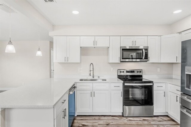 kitchen with white cabinetry, stainless steel appliances, light wood-type flooring, and sink