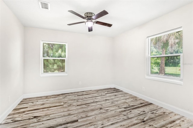 spare room with ceiling fan, wood-type flooring, and plenty of natural light