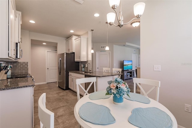 dining area featuring sink and a notable chandelier