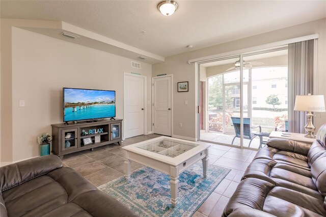 living room with ceiling fan and tile patterned flooring