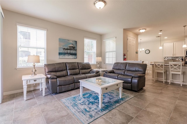 living room with light tile patterned flooring, plenty of natural light, and a chandelier