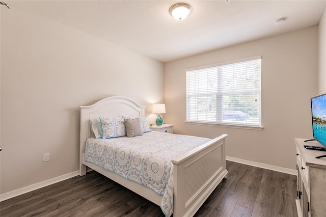 bedroom with dark hardwood / wood-style flooring and a textured ceiling