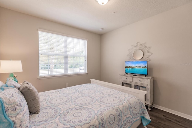 bedroom with dark wood-type flooring and a textured ceiling