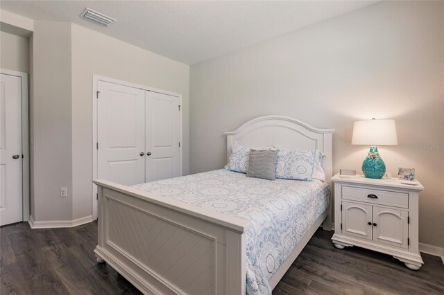 bedroom featuring dark hardwood / wood-style flooring and a closet