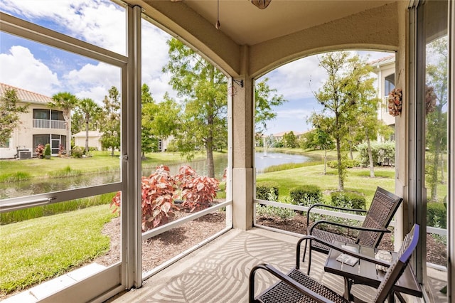 sunroom / solarium featuring a water view