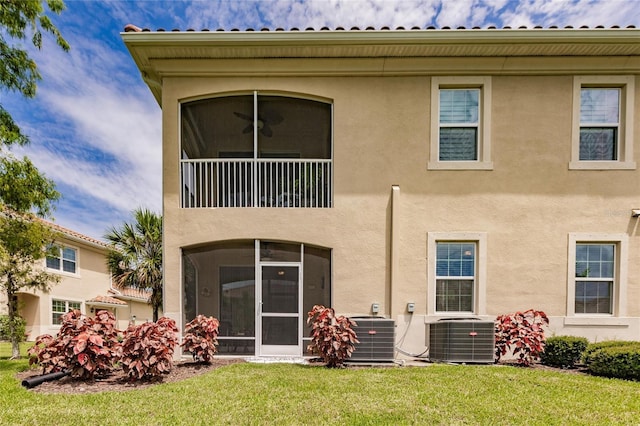 back of property with a yard, central AC, and ceiling fan