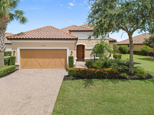 mediterranean / spanish house featuring a garage and a front yard