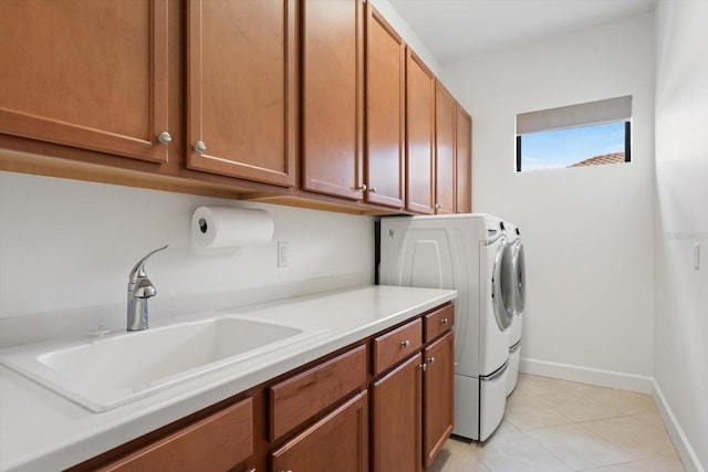 laundry area featuring light tile patterned floors, cabinets, sink, and washer and clothes dryer