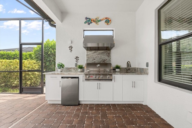 view of patio with exterior kitchen, sink, and a grill