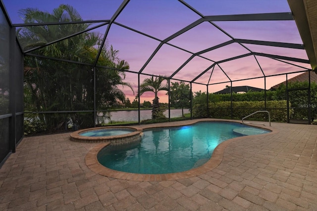 pool at dusk with glass enclosure, a patio, and an in ground hot tub