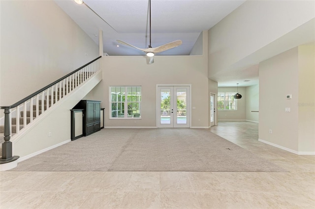 unfurnished living room with a high ceiling, french doors, and tile patterned floors