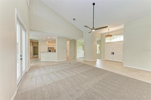 unfurnished living room featuring ceiling fan, high vaulted ceiling, and light colored carpet