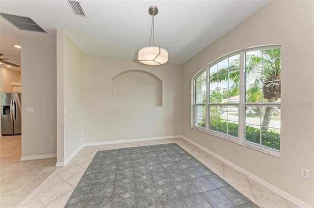 tiled spare room with ceiling fan