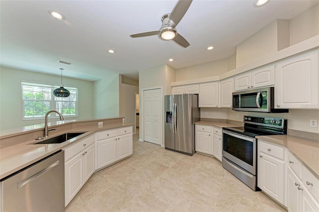 kitchen featuring stainless steel appliances, ceiling fan, pendant lighting, sink, and white cabinetry