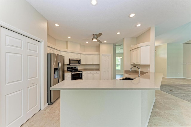 kitchen with ceiling fan, kitchen peninsula, light tile patterned flooring, and stainless steel appliances