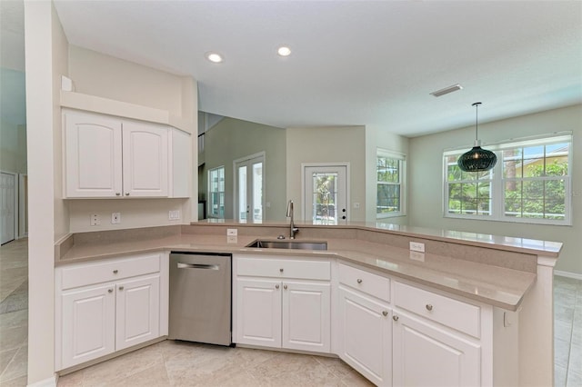 kitchen featuring stainless steel dishwasher, sink, white cabinetry, and kitchen peninsula