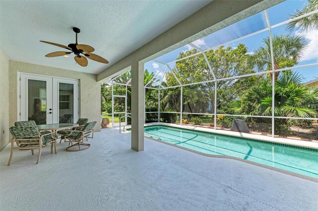 view of pool with french doors, glass enclosure, ceiling fan, and a patio area