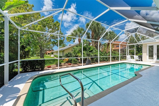 view of pool with glass enclosure and a patio