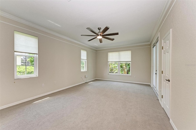 carpeted empty room featuring ceiling fan and crown molding