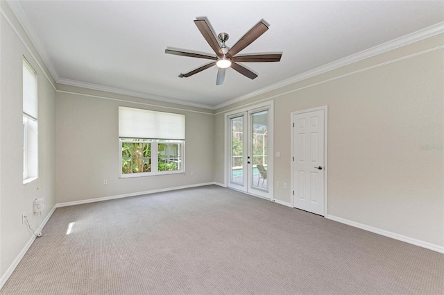 carpeted spare room featuring french doors, ornamental molding, and ceiling fan