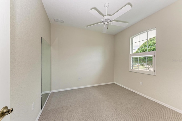 spare room with ceiling fan and carpet