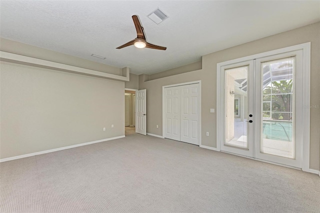 unfurnished bedroom with a closet, french doors, ceiling fan, access to exterior, and light colored carpet