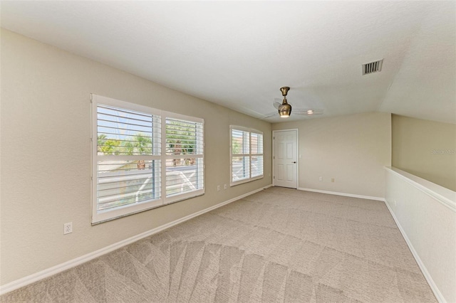 carpeted empty room featuring ceiling fan and vaulted ceiling