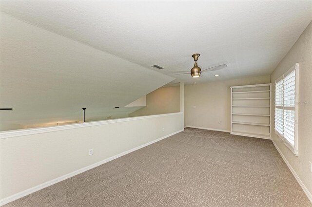 bonus room with ceiling fan, a textured ceiling, light carpet, and lofted ceiling