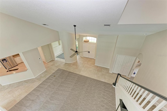 living room featuring a textured ceiling, high vaulted ceiling, and light colored carpet