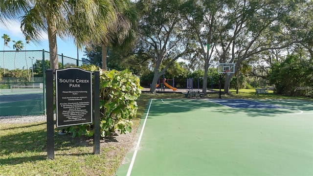 view of sport court featuring tennis court and a playground