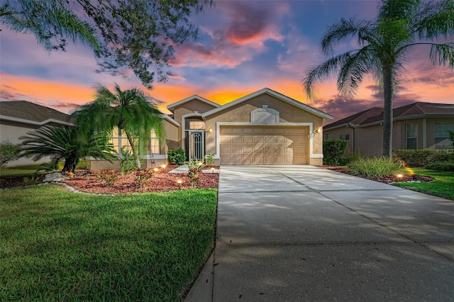 ranch-style house featuring a garage and a lawn