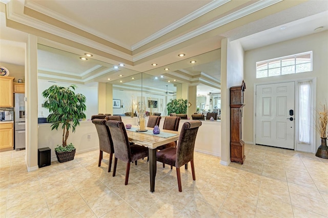 dining room featuring a raised ceiling, crown molding, and light tile patterned floors