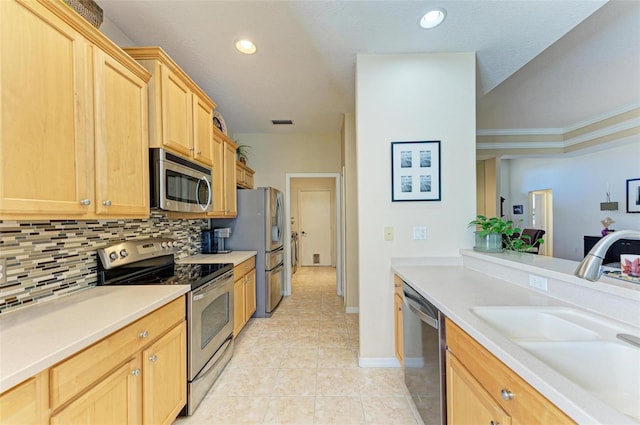 kitchen with appliances with stainless steel finishes, ornamental molding, decorative backsplash, light brown cabinets, and sink