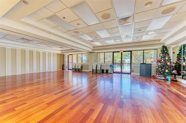 exercise area with a paneled ceiling and wood-type flooring