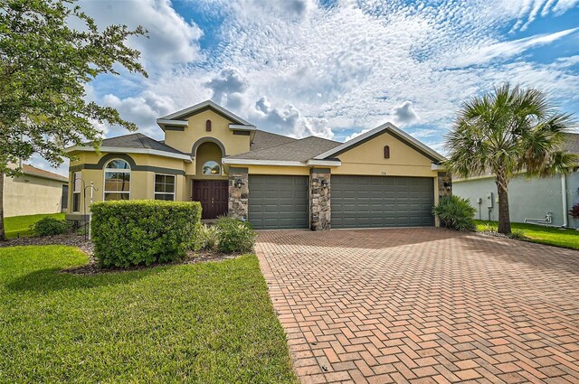 view of front of property featuring a front lawn and a garage