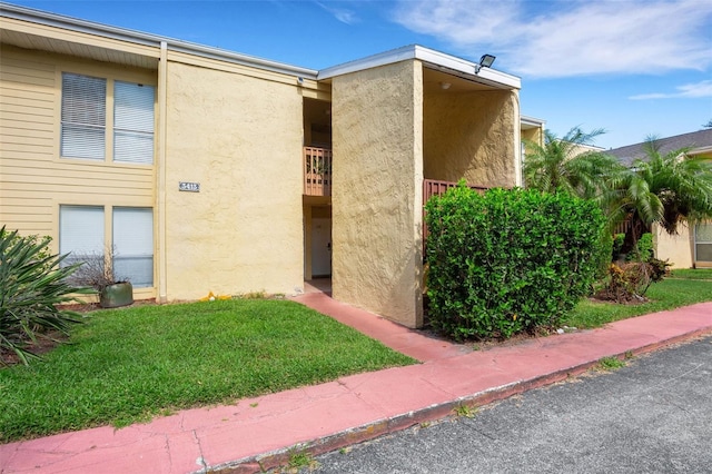 view of home's exterior with a yard and stucco siding