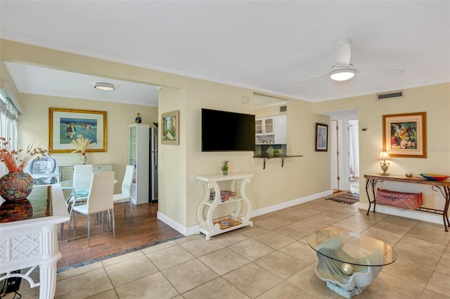 living room with ceiling fan, light wood-type flooring, and ornamental molding