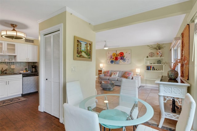 dining space with ceiling fan, sink, hardwood / wood-style flooring, and crown molding