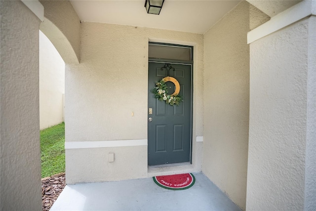 view of exterior entry featuring stucco siding