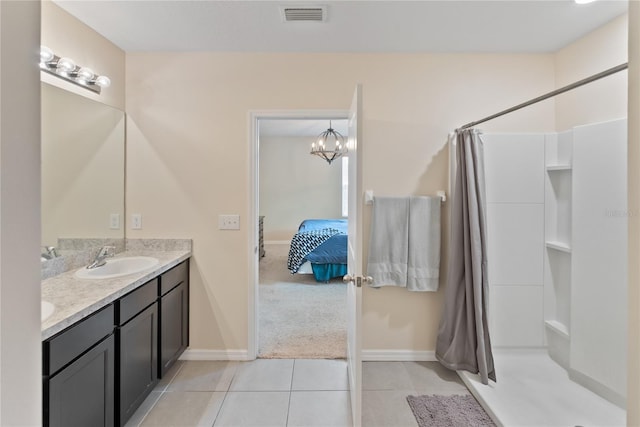 bathroom with connected bathroom, a sink, visible vents, tile patterned floors, and double vanity