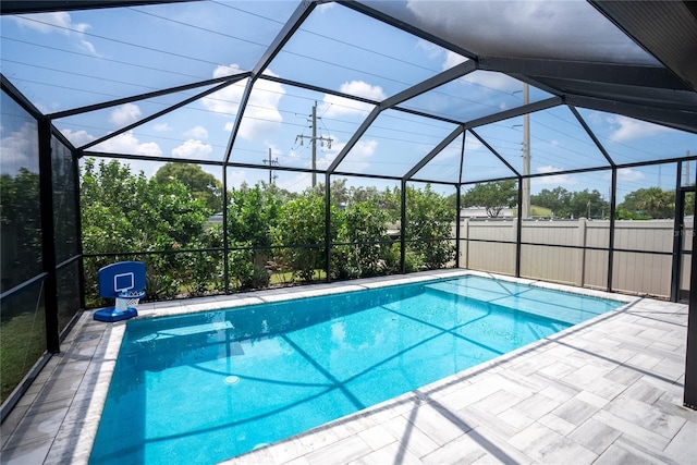 pool featuring glass enclosure and a patio area