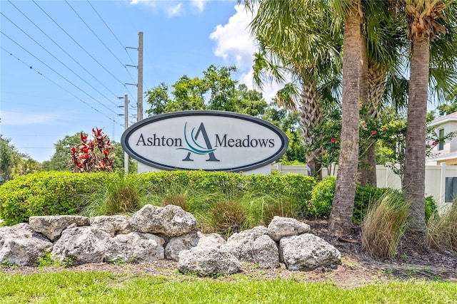 community / neighborhood sign featuring fence