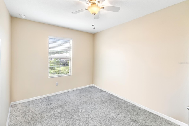 carpeted spare room with ceiling fan and baseboards