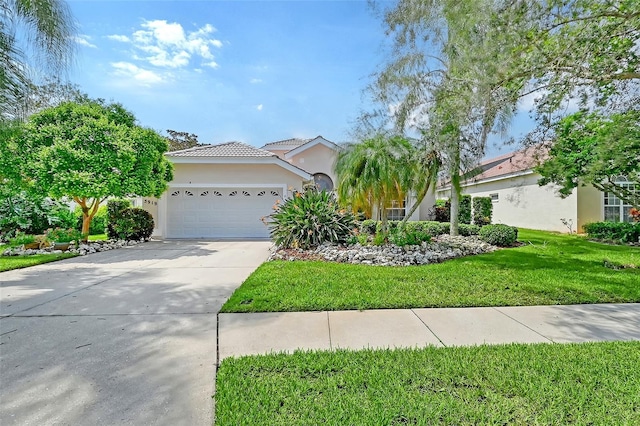 mediterranean / spanish-style home featuring a front yard and a garage