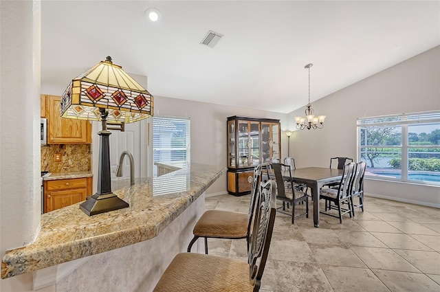 dining area featuring a chandelier and vaulted ceiling