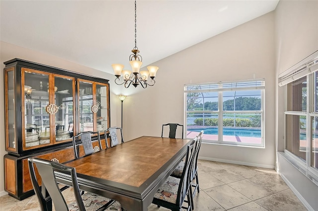 dining area with a chandelier, light tile patterned floors, and lofted ceiling