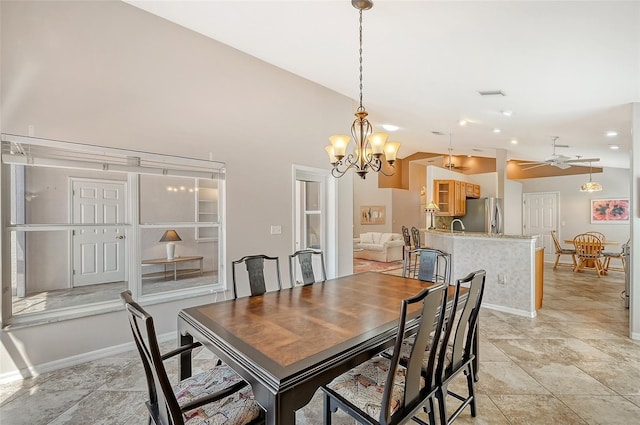 dining room with sink, ceiling fan with notable chandelier, and vaulted ceiling