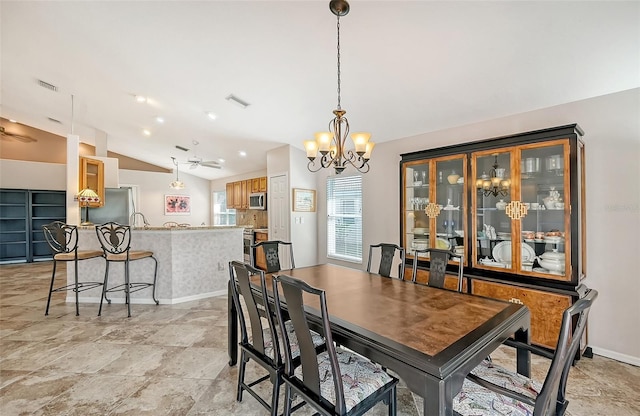 dining space featuring ceiling fan with notable chandelier and vaulted ceiling