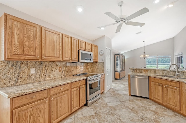 kitchen featuring light stone counters, stainless steel appliances, sink, pendant lighting, and lofted ceiling