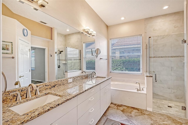 bathroom with vanity and shower with separate bathtub